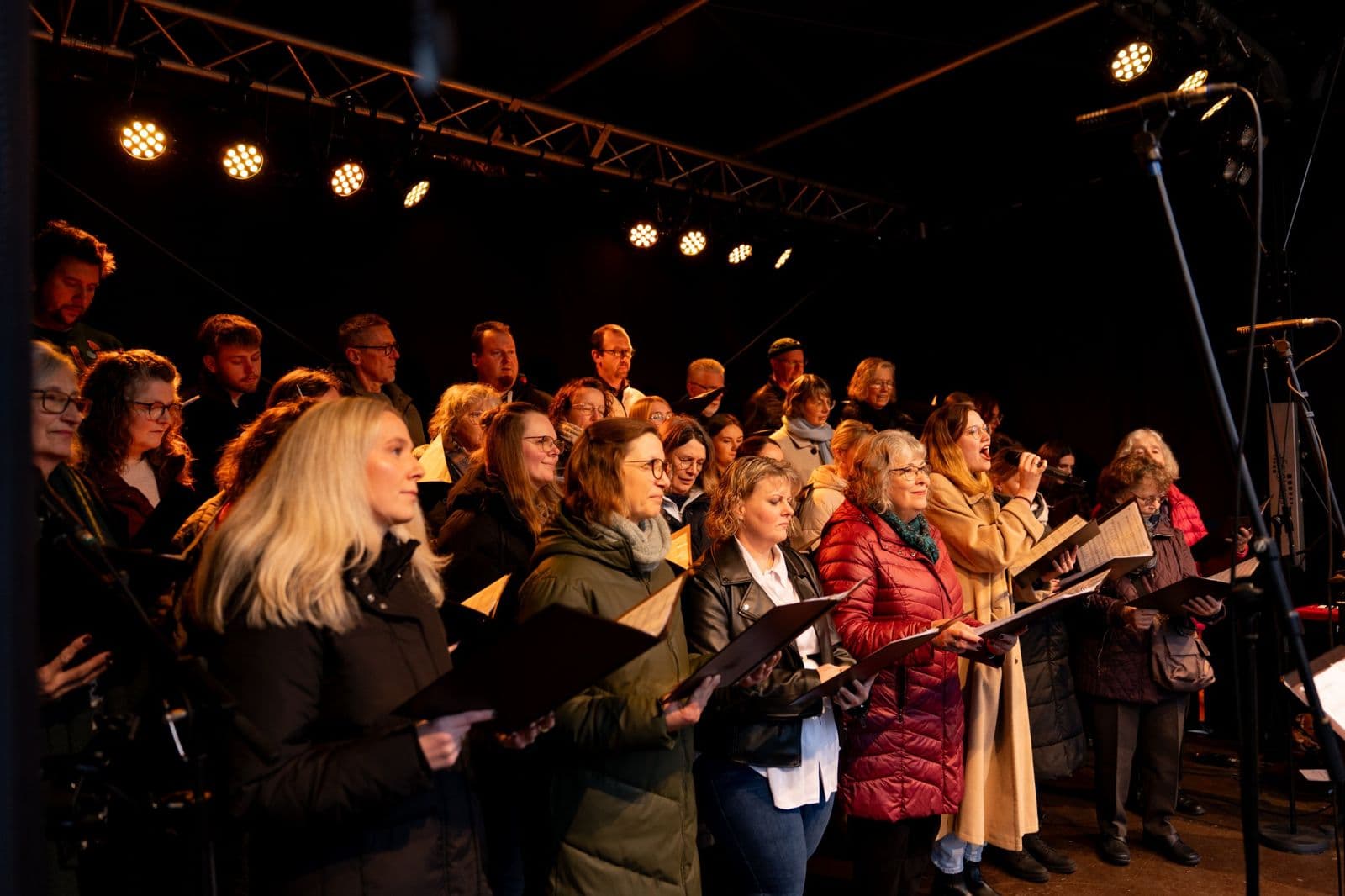 Gemeindechor singt auf der beleuchteten Bühne beim Lichterfest